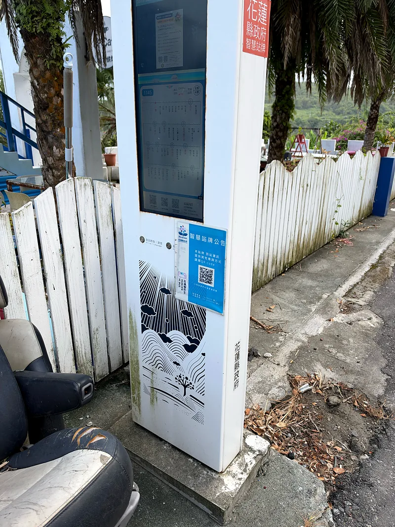 莊園門口的小港公車站:花蓮縣政府智慧站牌,旁邊是白色木柵欄與台11線人行道