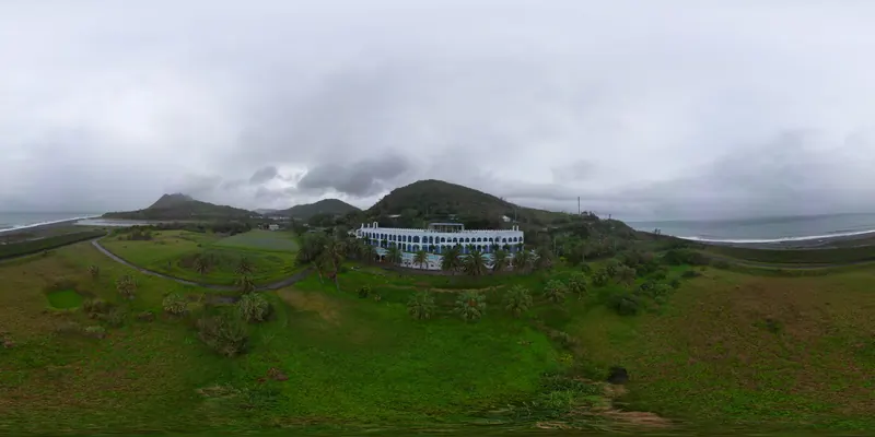 360° 空拍環景：靠近白色建築與後方青山